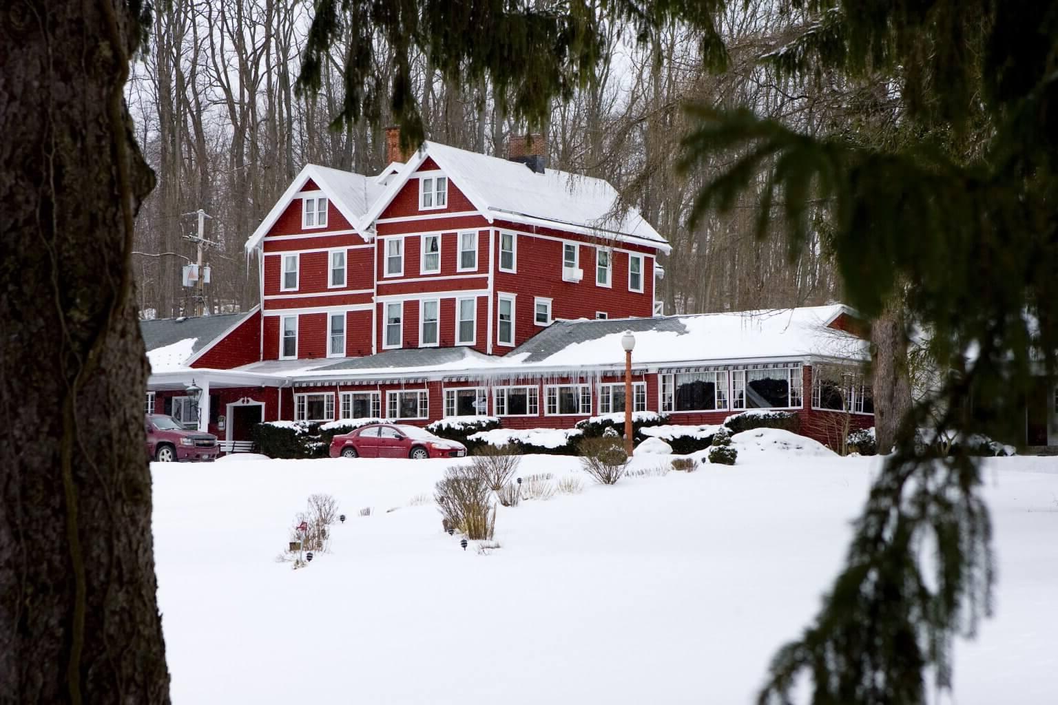 Exterior of an Inn in the winter with the ground covered in snow